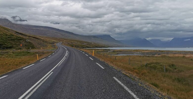 Strada lungo un fiordo islandese con cielo nuvoloso
