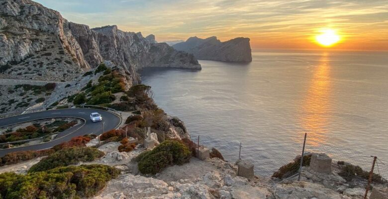 Tramonto sulla scogliera di Cap de Formentor con strada e auto