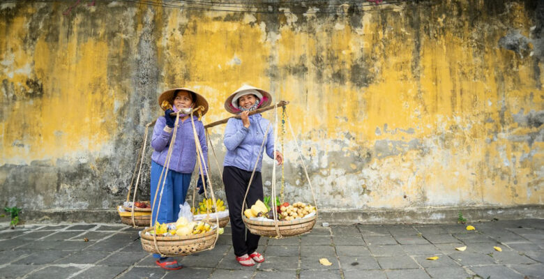 Due signore in Vietnam portano cesti di frutta