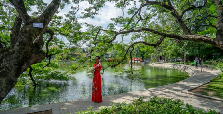 Sposa vietnamita vestita di rosso con un bouquet ad Hanoi