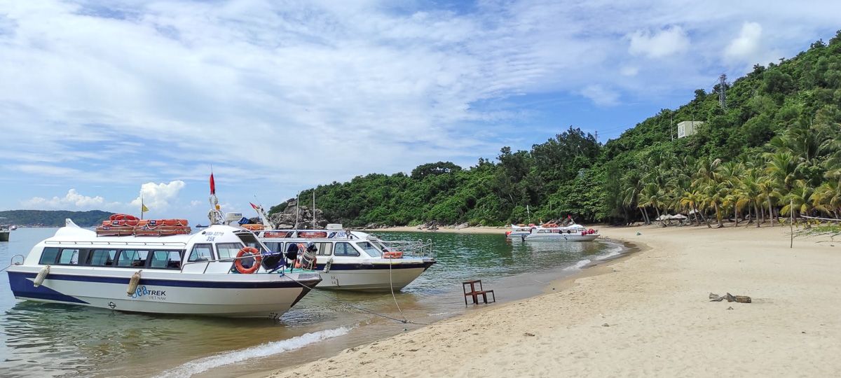 spiaggia delle isole Cham con palme e la barca del tour di snorkeling