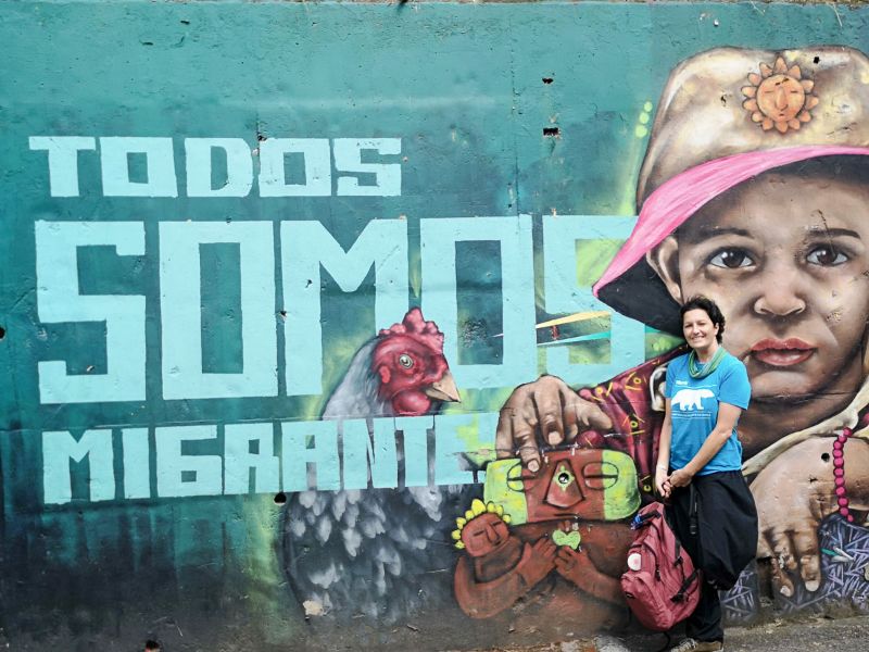 Martina davanti al murale "todos somos migrantes" alla Comuna 13