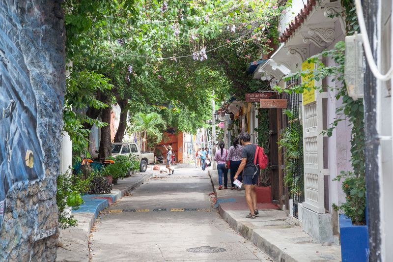 Una strada sotto le fronde di alberi del quartiere Getsemani a Cartagena de Indias